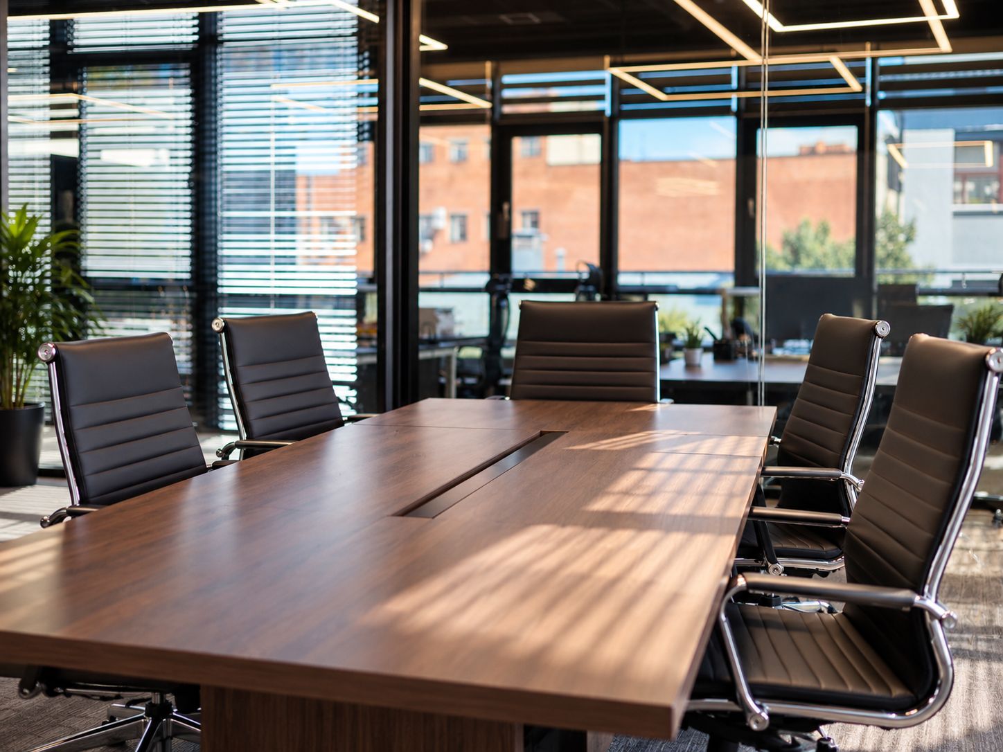 Sala de juntas con mesa de madera y sillas de cuero